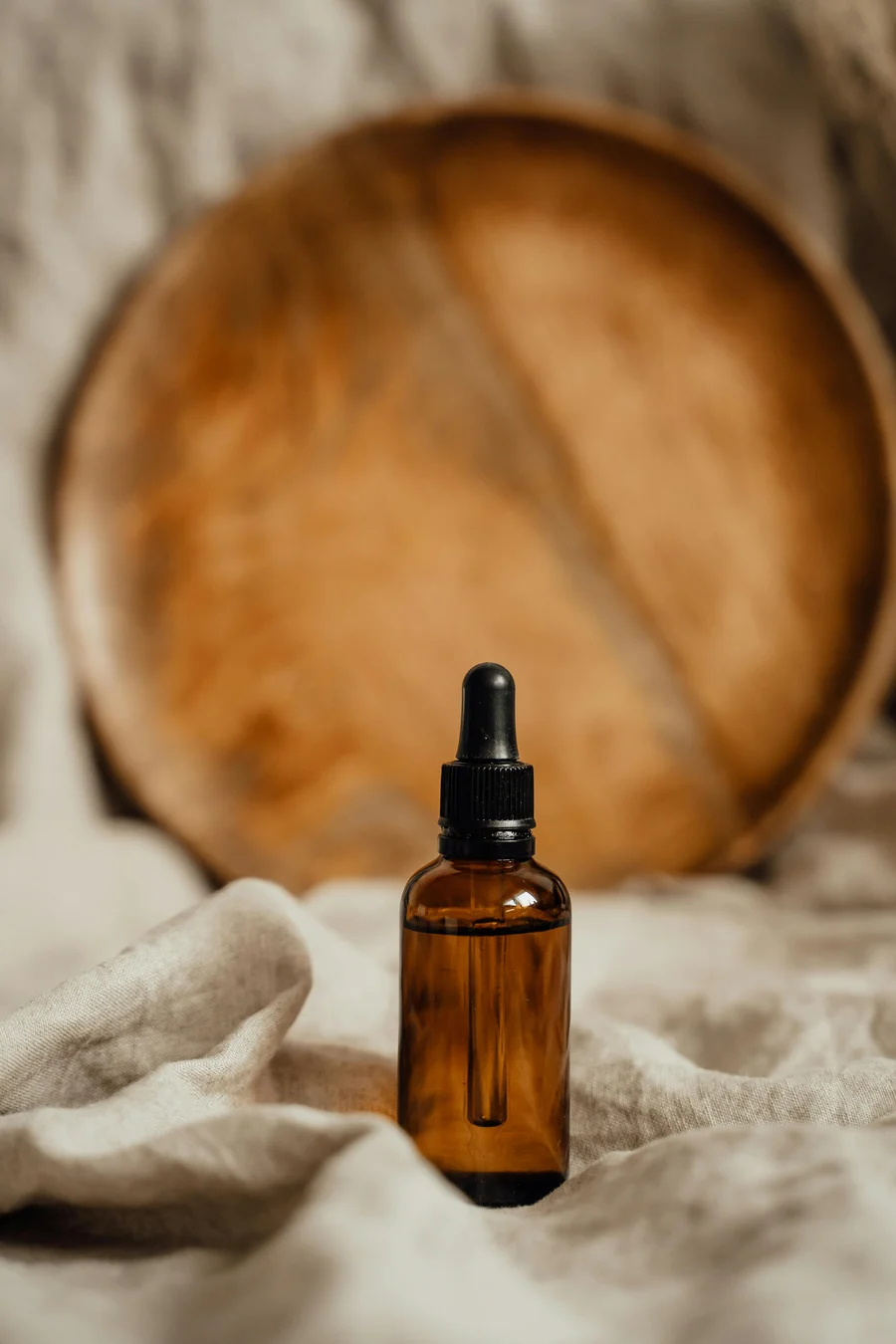 Amber glass dropper bottle on natural linen